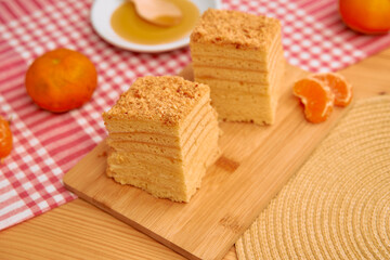 Delicious honey cake with mandarin oranges on rustic wooden table setting