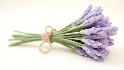 Fototapeta premium Delicate lavender bouquet tied with twine presents a simple beauty and evokes serenity in a close-up studio setting showcasing its graceful stems and soft, pastel purple blooms.