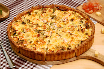 Delicious homemade quiche with broccoli and cheese on checkered tablecloth