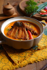 bowl of smoked fish cooked in spicy curry named mangut in Bahasa 