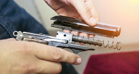 Disassembling a firearm in a workshop setting during daylight hours for maintenance and cleaning