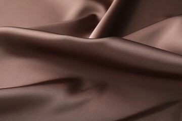 Crumpled light brown silk fabric as background, closeup