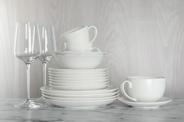 Different clean dishware on white marble table indoors