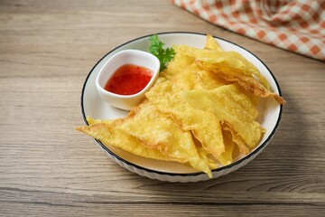 Deep Fried Wontons in white plate on wooden background	