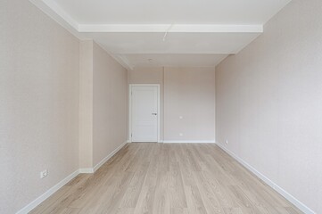bright, empty room with light wood floors, beige walls, white trim and door. Clean and modern...