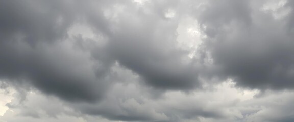 Fototapeta premium Thick, grey clouds dominate an overcast sky, muted light diffusing evenly, stormy, diffused light