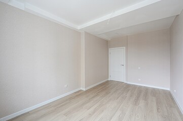 bright, empty room with light wood floors, beige walls, white trim and door. Clean and modern...