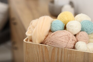 Felting wool and knitting yarn in wooden basket indoors, closeup