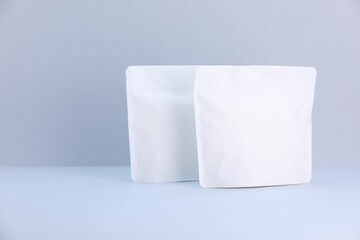 Two zipper stand-up pouches on light grey background. Mockup for design