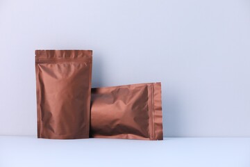 Two zipper stand-up pouches on light grey background. Mockup for design