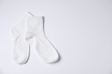 Pair of comfortable socks on white background, top view. Space for text