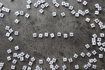 Word Maximum made of cubes on grey table, flat lay