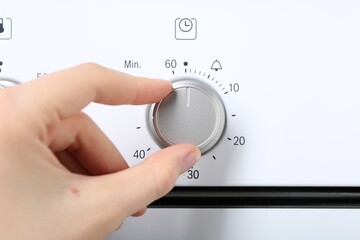Maximum concept. Woman turning on oven, closeup