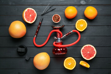 Hookah, coal and fresh fruits on black wooden table, flat lay