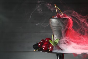 Hookah with cherries and smoke on black background, closeup. Space for text