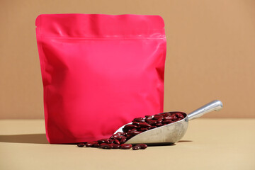 Zipper stand-up pouch and dry kidney beans on beige background, closeup. Mockup for design