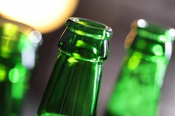 Bottle of tasty beer on blurred grey background, macro view