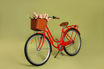 Bicycle with basket of beautiful flowers on green background