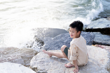 young boy sitting on rocks