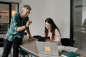 Two coworkers working together on a project in a contemporary office environment