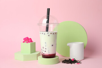 Tasty refreshing bubble tea and flower on pink background
