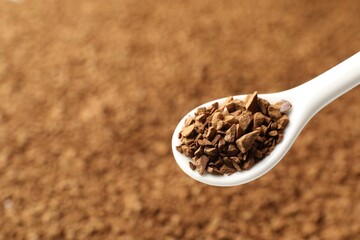 Spoon with aromatic instant coffee as background, closeup