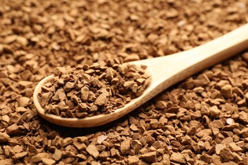 Spoon with aromatic instant coffee as background, closeup