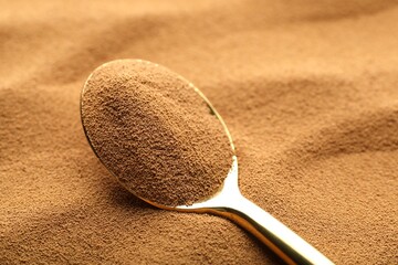 Spoon with aromatic instant coffee as background, closeup