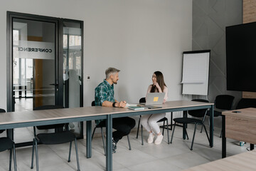 Professional exchange between coworkers in a bright and organized conference room