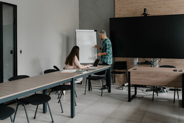 Professional colleagues working together in a modern office, interacting with charts and devices.