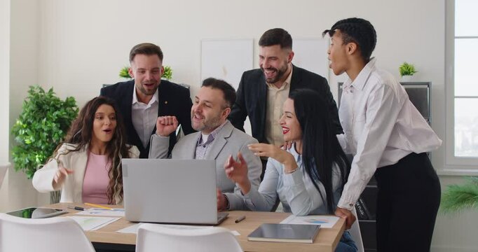 Team of business people celebrate success, working together with laptop and applauding in office, togetherness with triumphant vibes, transforming the workspace into a hub of achievement and joy.