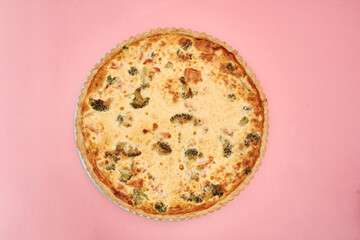 Delicious broccoli cheese quiche on pink background showcasing golden crust and savory ingredients