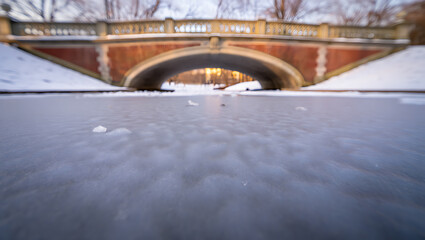 Ornate bridge over frozen water with snow winter