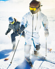 Two advanced young skiers having fun on alpine slope demonstrates an extreme carving skiing style...