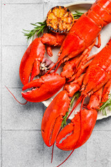 Seafood. Two whole boiled red lobsters on a plate with ice, top view.