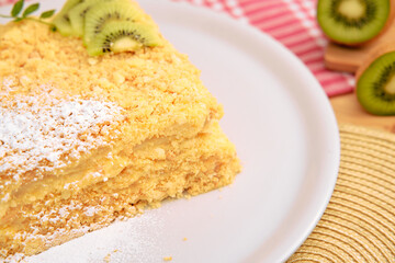 Lemon kiwi crumble cake with powdered sugar on white plate