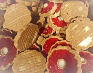 Homemade shortbread spicy cookie with red hearts with jam on white plate on gray textured background, for valentine's day. flat lay
