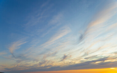 sunset blue and orange sky with thin and curved cloud