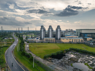 Aerial view of the expansive power plant complex, where towering silver structures meet the verdant earth under a vast, moody sky, Lagos, Nigeria.