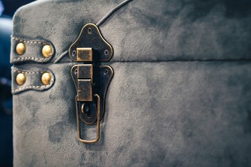 Close-up of an antique trunk's brass lock, emphasizing texture and old-world elegance.