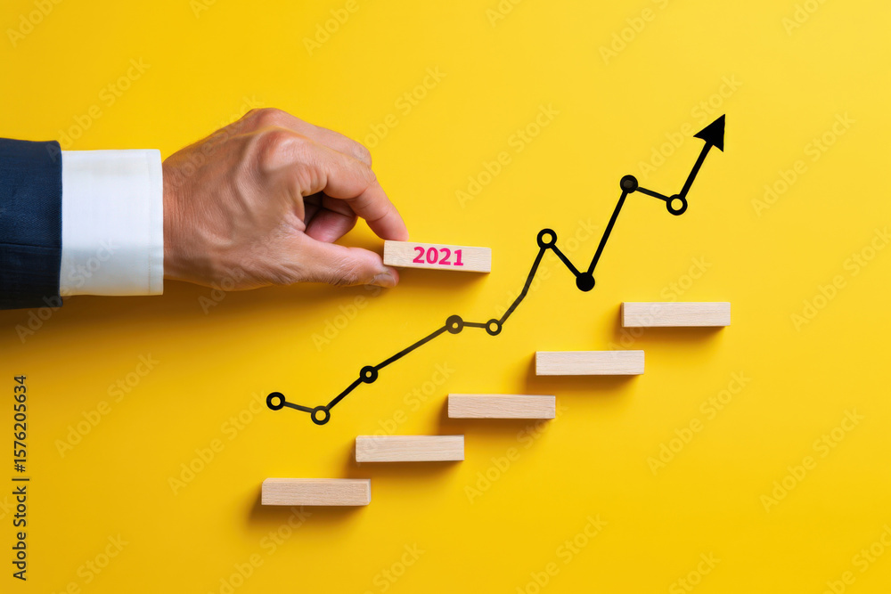 Poster building towards success a hand places a wooden block with the year 2021 on steps leading to an upwa