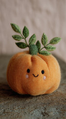Cute pumpkin with embroidered leaves and smiling face on textured surface