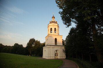 Obraz premium Beautiful old bell architecture building from white marble on nature bright sunny sunset light and blue sky background in the summer park on the hill