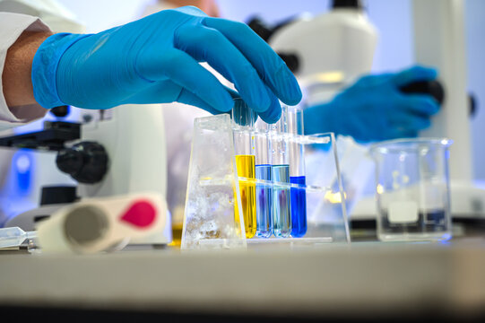 Close up unknown scientist working with testing tube in laboratory
