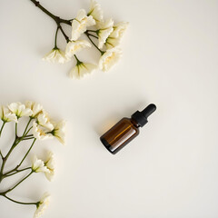 Essential oil bottle or skincare product bottle on a minimalist white background with plants and floral decorations. Marble stone table or pedal. Sunlight with plant shadow. aromatherapy and spa