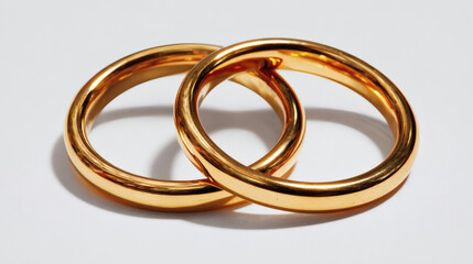 Gold wedding rings intertwined, symbolizing love and commitment for a lifetime.