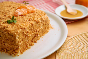Tangerine garnish honey drizzle cake with mint on checkered cloth background