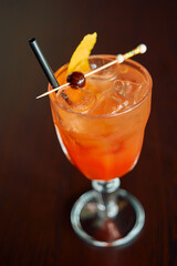 Refreshing orange cocktail with ice and garnish in elegant glass