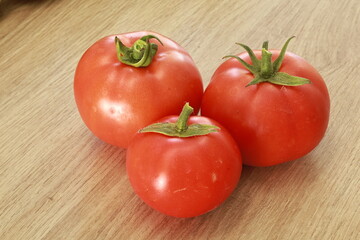 Three ripe tomatoes on the table.