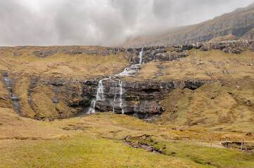 View of waterfall. Green hills at Faroe Islands 2022